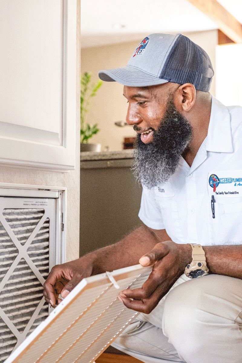 Wisler AC technician replacing air filter.