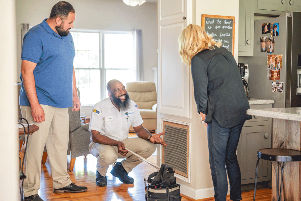 Wisler AC technician showing customer air filter.