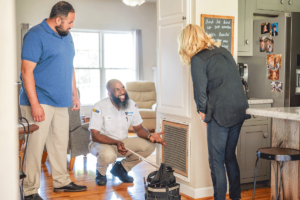Wisler AC technician showing customer air filter.